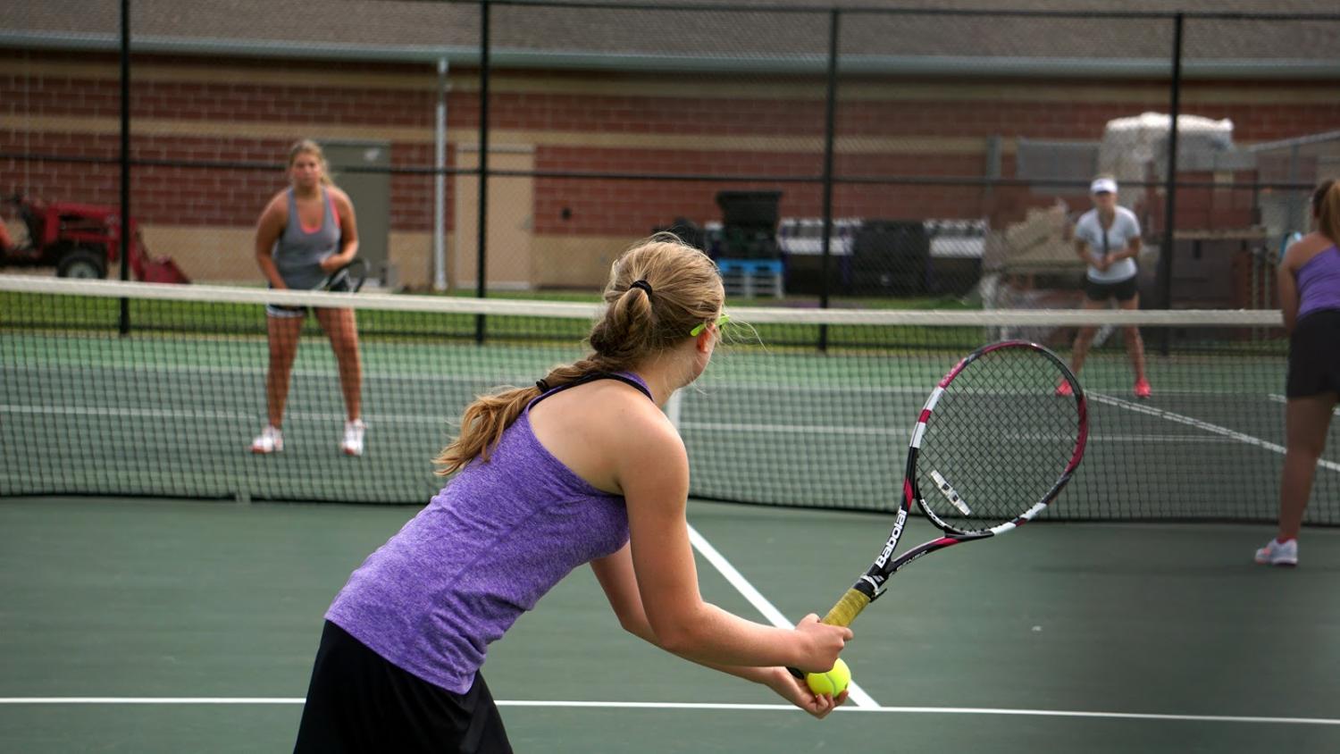 During the first tennis match of the season, KayLee Mitchell, 12, sets up for a serve. The Lady Broncos defeated Lansing in both varsity and Jr. Varsity matches. (photo by J. Barnett)