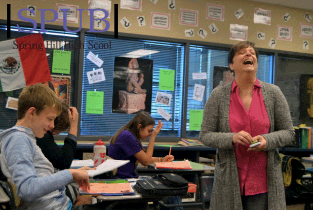 Marlene Oxner, Spanish teacher, throws her head back laughing after student, Evan Robinson, 11, makes joke about that days Tocatimbre. After that Oxner signed his calendar and Evan was then all caught up with the rest of the class. (Photo By O.Amos)

