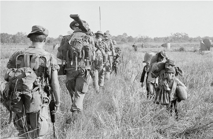 Members of the 25 Infantry Division  passing a group of South Vietnamese farmers.  (Photo by © Bettmann/CORBIS) 