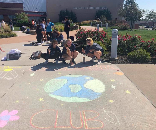 At Chalk the Walk some of the Environmental Club members, Julianna Allenbrand, 10, Brooke Powell, 10, and Morgan Bruckener, 10, chalk their square to bring awareness. (Photo submitted by K. Wilson)