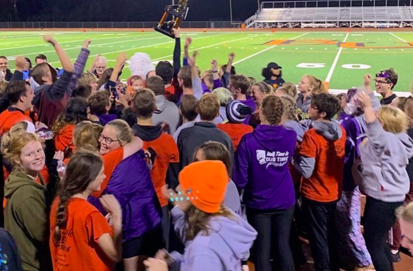 The band celebrating their big win at Baker University on Oct. 23. Drew Fabrizius, 12, is in the middle of the huddle holding their trophy high. (Photo submitted by J. Gallagher)