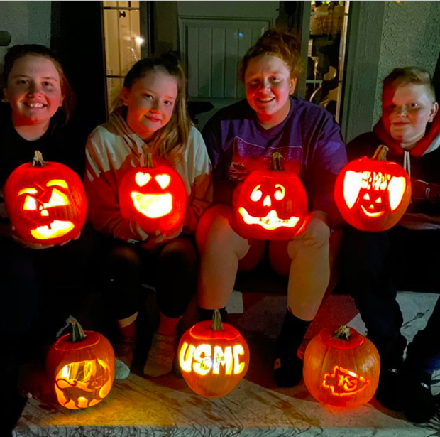 Posing for a picture, Kenzie Rios, 12, and her siblings show off their pumpkins. The pumpkin in the middle on the bottom is a pumpkin they carved for their brother who is away serving in the military (Photo submitted by Kenzie Rios).
