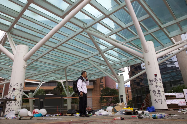 Alex Wai, the vice president of the Polytechnic University, taking in the vandalized school. He’s leading a team of officials to look for holed up protesters (Photo Courtesy of the Associated Press).