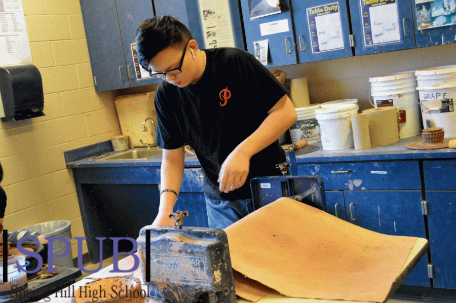 During his second hour ceramics class, You Yang, 12, puts the ceramic clay through a slab roller. This machine takes the clay and flattens it into large slabs to be cut to the desired size and shape of the artist (Photo by J. Haworth).
