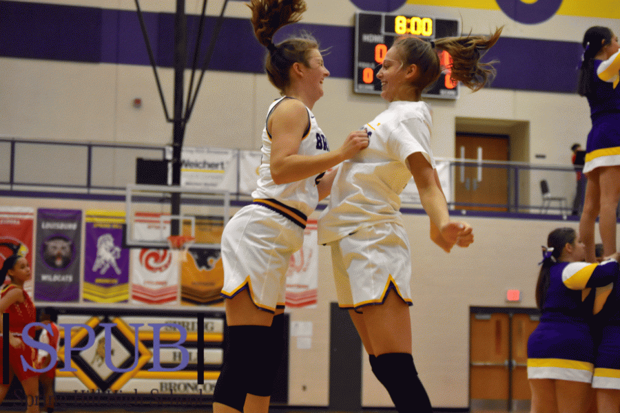 As Avery Anderson, 12, is announced as part of the starting line up she runs through her teams tunnel to give teammate Ali Frank, 11, a chest bump. The Broncos get ready for their season opener against Atchison at home (Photo by A. Frigon).