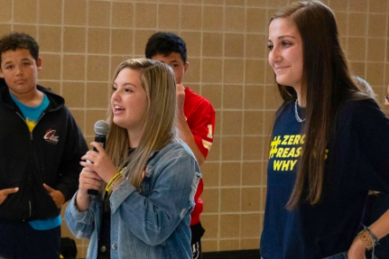 On Nov. 22, Kyra Fuchs, 11, and Sloane McKinney, 12, speak to the middle schoolers about suicide awareness. Soon after, they pass out wristbands and stickers (Photo courtesy of Zero Reasons Why official instagram).