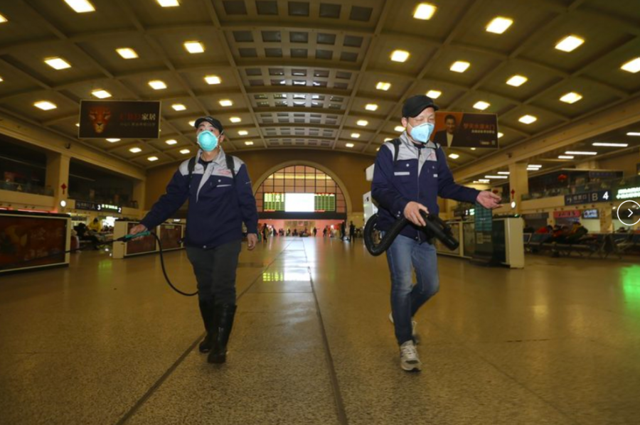 In a train station in Wuhan, the origin of a new viral illness, workers spray disinfectant. All outgoing trains and flights have been cancelled to help stop the spread of the virus (Photo curtesy of (Chinatopix via AP).