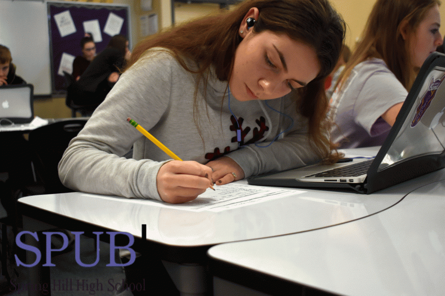 In her fourth hour Algebra 1 class, Abigail Sparks, 9, listens to music while she works on her math review. Her class is getting ready for a test later that week (Photo by D. Birk).