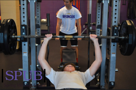 On Nov. 21, in their Weights class Zack Philips, 10, bench presses while Tristan Taylor, 10, sets up his weights. They are hoping to maintain their health by doing this one small thing (Photo by KRios). 
