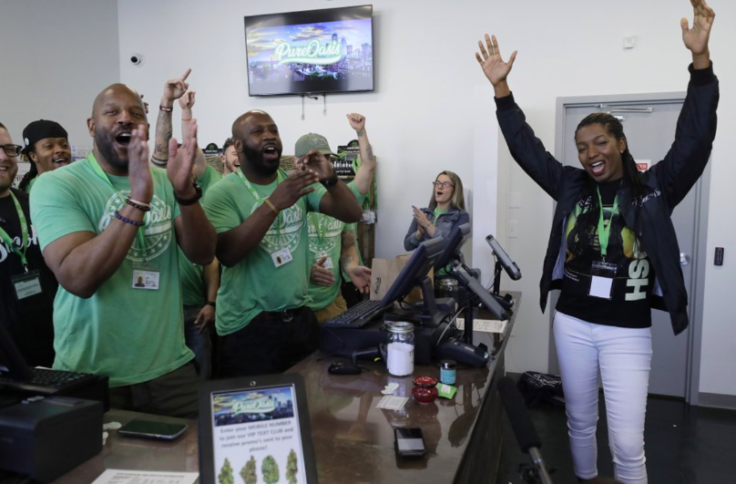 Celebration insues after the first sale made by Pure Oasis, on opening day, March 9. Kobie Evans and Kevin Hart, owners, are the first to open a recreational cannabis shop in Mass..