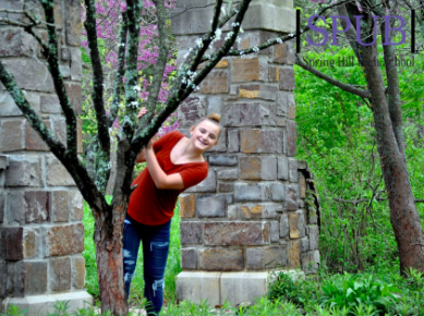 On April 24, Alynna Mattox, 9, felt creative to pose behind this tree during a field trip to the arboretum. Mattox is preparing to go on a trip over spring break (Photo by AMarney).