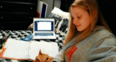 Lily Haney, 9, does math assignments in her room. Her cat, Dino, is one of the distractions that makes it harder for Haney to focus on her work (Photo submitted by L. Haney).
