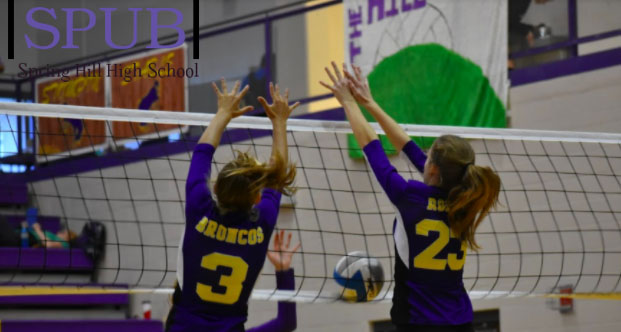 On Sept. 14, 2019, Jenna Weber, 10, and Jordan Anderson, 11, jump to block a ball against Louisburg. The first positive coronavirus case was contracted by a volleyball player, but there is no evidence to say that is where she contracted it (Photo by I. Williams). 
