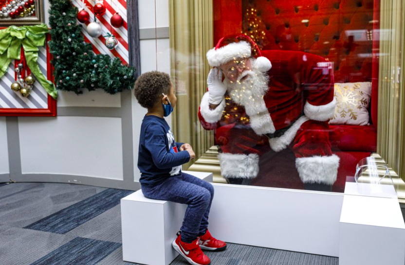The Capital City Mall in Pennsylvania is another business who found a unique way to adapt traditions changed by COVID-19. Their Santa Claus sits behind a wall of plexiglass to speak with children, making sure everyone stays safe while still experiencing the magic of the holidays (photo courtesy AP News).
