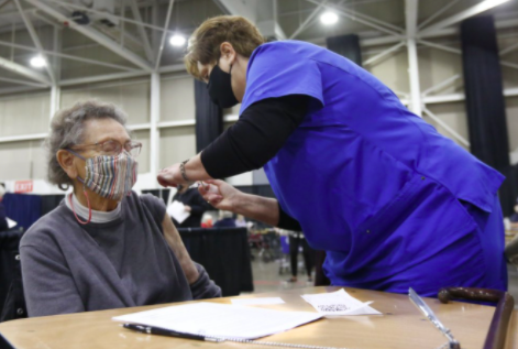 Tami Morrison, right, is giving Lisetta White her first COVID-19 vaccination (photo courtesy AP news).