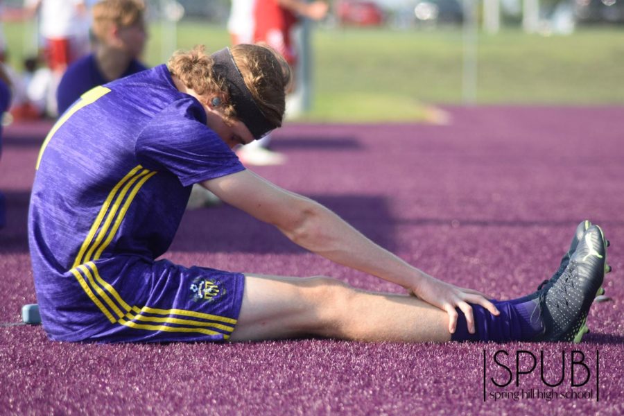 On Sept. 6, varsity soccer player Tyler Spiegelhalter, 12, stretches and listens to music before a game. 