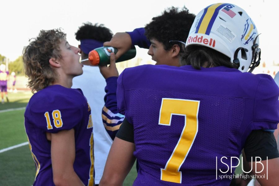 On Sept. 12, Draven Pipkin, 12, gives water to JV football player Syler Stewart, 9.