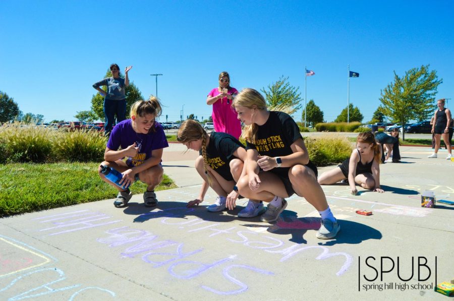 On Sept. 20, Avery Donahey, 10, Isabella Farris, 12, and Kaylynn Ottenschnieder, 11, make a chalk drawing promoting wrestling at the Chalk the Walk event.