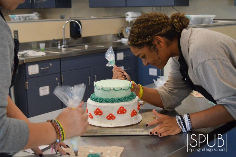 On Oct. 7, Mya January, 11, carefully pipes frosting onto her cake during her baking class.