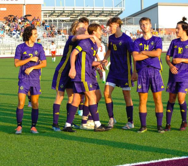The boys varsity soccer team gets hyped up for the game after warmups (photo by P. Vogelbacher).