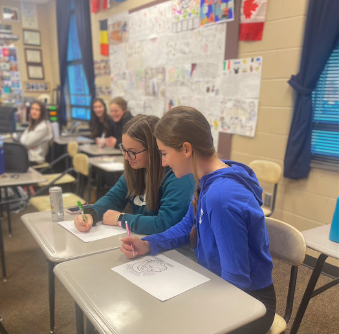 Ava Crabtree, 10, and Gianna Cowsert, 10, demonstrate what it looks like to cheat on a test (photo illustration by B. Pierson).