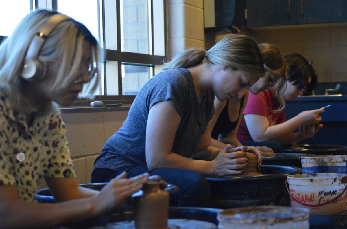 Sydney Goldman, ceramics teacher, works alongside students to make a bowl during class. Goldman regularly works with clay to demonstrate techniques and for fun. (Photo by H. Evans)
