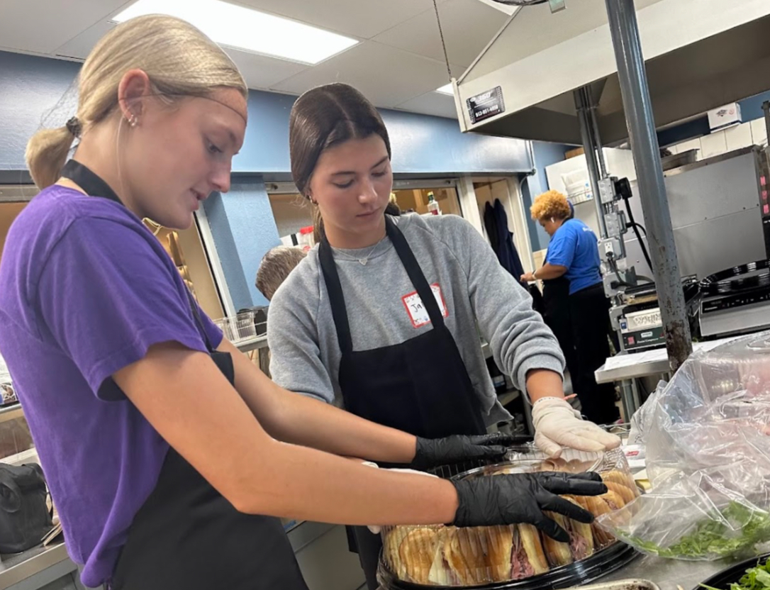 Elizabeth Suter, 11,  and Jaleigh White, 11, packaging food at their planned volunteer trip. Thelma’s Kitchen. There, members of Volunteer packaged and made food for the less fortunate (Photo by C. Holmes). 
