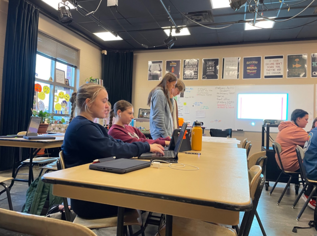Rylee Jones, 10, and Maddie Brown, 10, work on their yearbook content during third hour. Hannah King, 11, and Luke Torrez, 12, look at yearbook templates and decide what to use for their story (Photo by H. Mueller). 