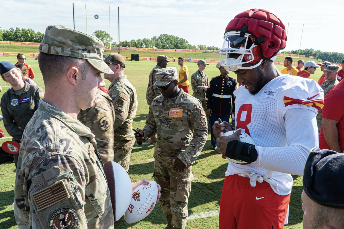 Kansas City Chiefs WR Justyn Ross signs a football for a military member during practice. The Chiefs hold a military appreciation day during training camp to honor those who serve in the military. (M. Crane)