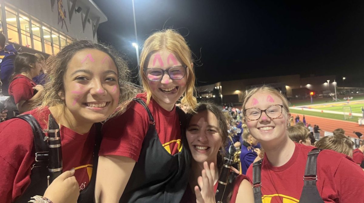 Tarvin takes pictures with fellow band members in the stands during the pink out game on Oct. 20. They enjoyed the theme while supporting the band and cheering on the football team (Photo by A. Fuqua). 