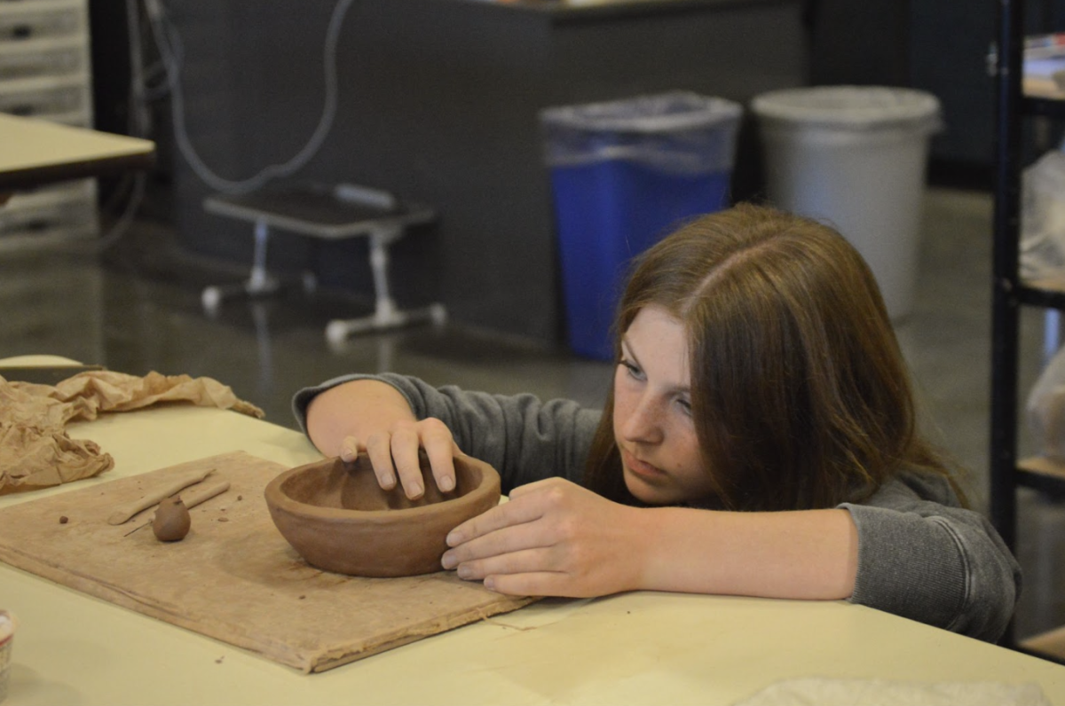Kenadee Staab, 11, focuses on creating her clay bowl in Ms. Goldman’s ceramics class. Second semester can come with switches in electives. (Photo by H. Evans)