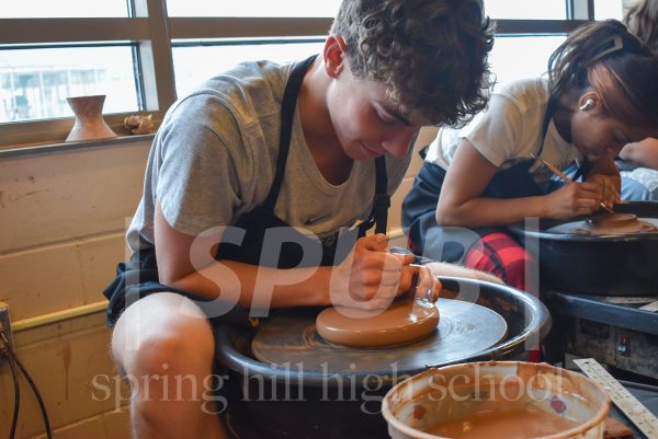 On Jan. 23, Logan Beckman, 11, carefully crafts and manipulates the clay while it spins on the wheel. The students practiced throwing on the wheel, and centering was the first step to this.
