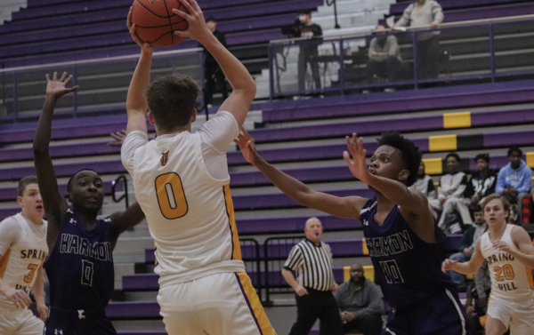 On Jan. 18, the Varsity Boys Basketball team competed against Harmon at the Spring Hill High School. Ryan Jackson, 11, looked to pass the ball out to teammates in order to avoid being trapped by two defenders. 