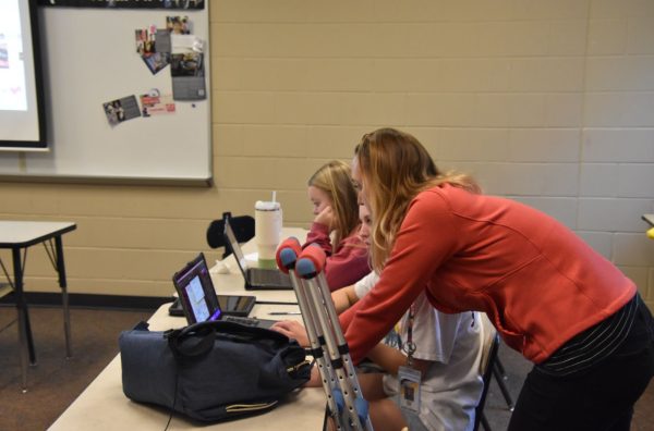 Catherine Hapke, teacher, giving assistance to Emma Kaiser, 9, on their assignment. Teachers engaging with students and helping them out when they need it are effective ways to encourage consistency and prevent missing assignments (Photo by C. Brewer).