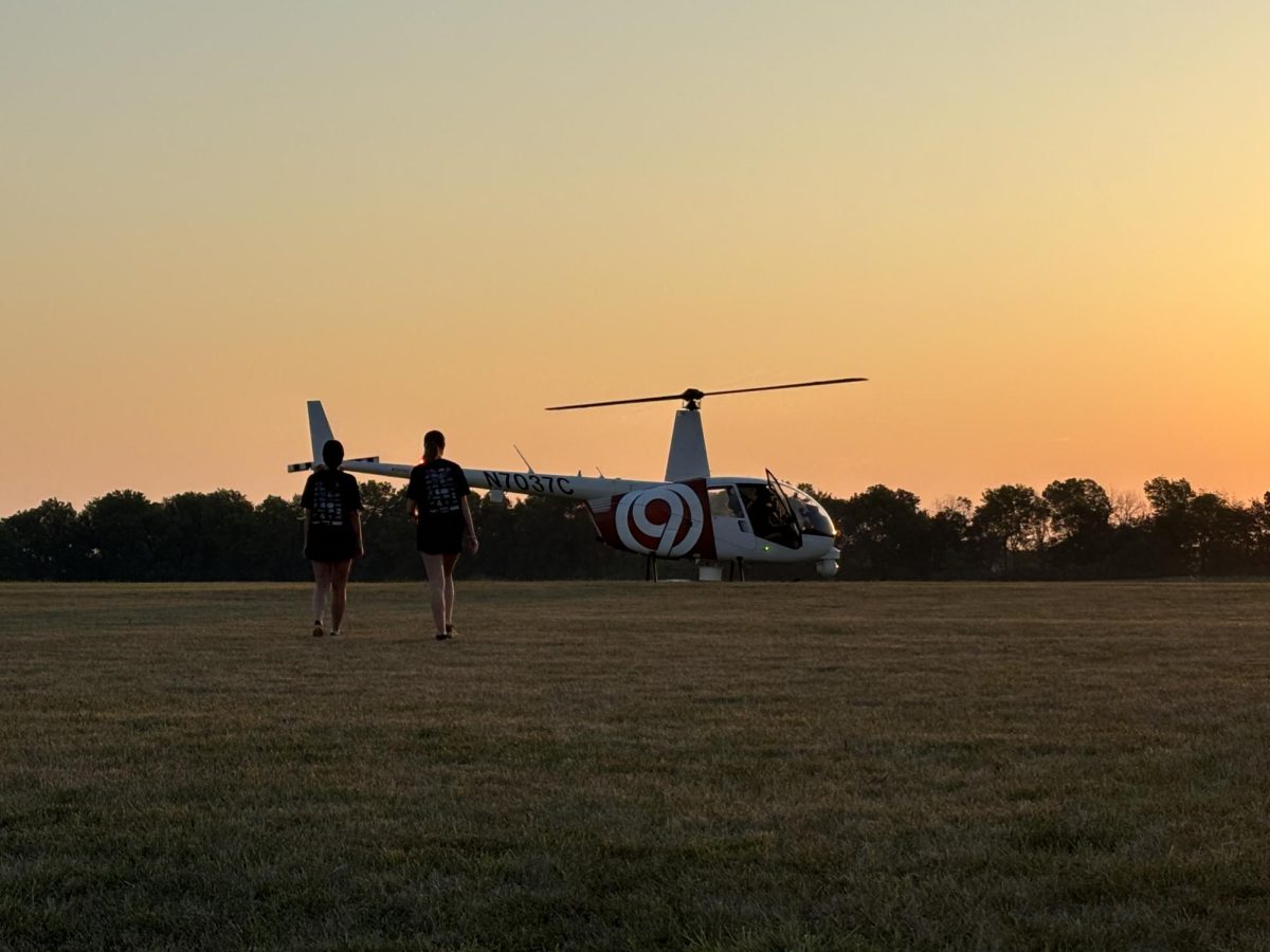 Drum Majors Nora Ide, 12, and Cymri Elton, 11, walk to the Channel 9 Chopper to greet Johnny Rowlands and introduce him to Marc Williams, principal, and Tristan Bartley, band director. Ide and Elton then joined in on the band's cheer. (Photo submitted by Tarvin)