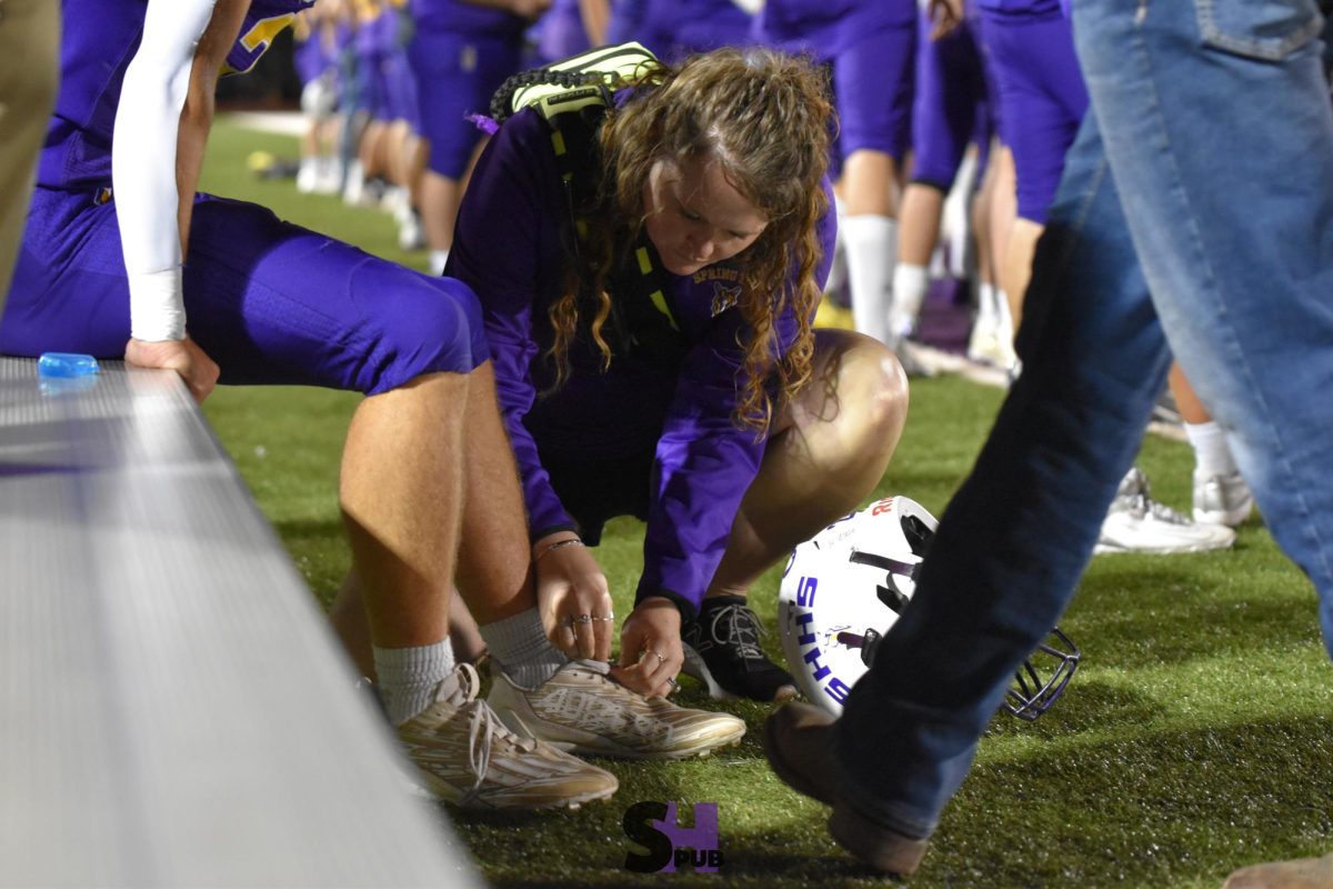 On Sept. 27, a football player gets patched up on the sidelines by Jamie Blackim, athletic trainer.