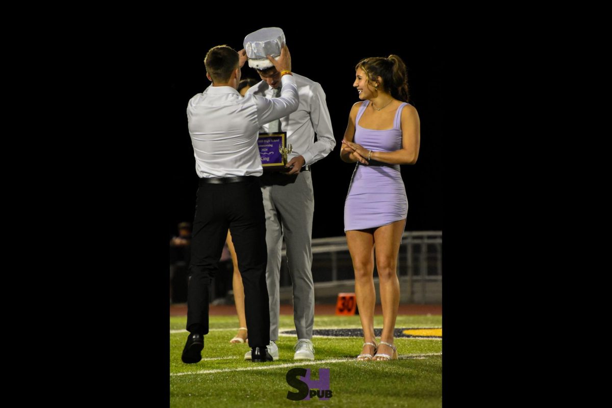 Noah Anderton, last year’s homecoming king, crowns Martin Frigon, 12 during the coronation ceremony Sept. 27.