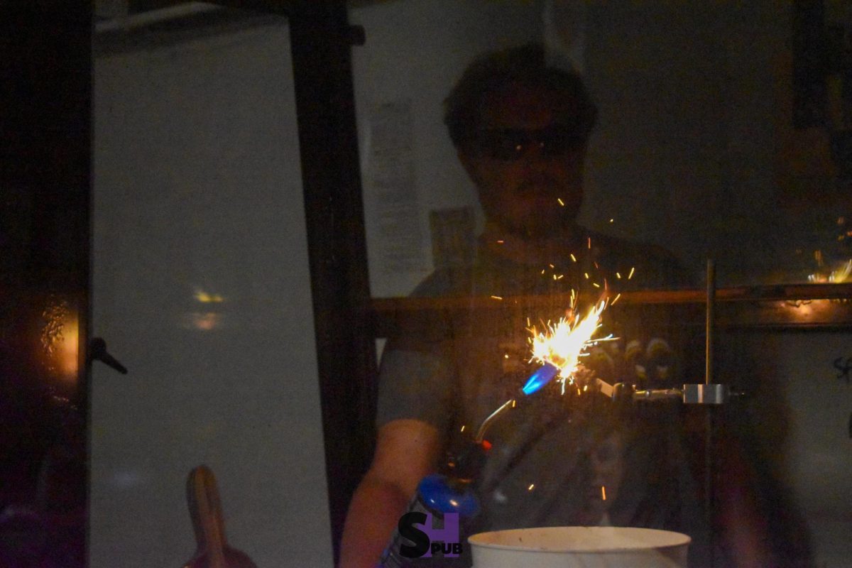 On Oct. 11, Matthew Lundy, honors chemistry teacher, demonstrates, from the fume hood, the reaction that takes place when a sparkler is lit.