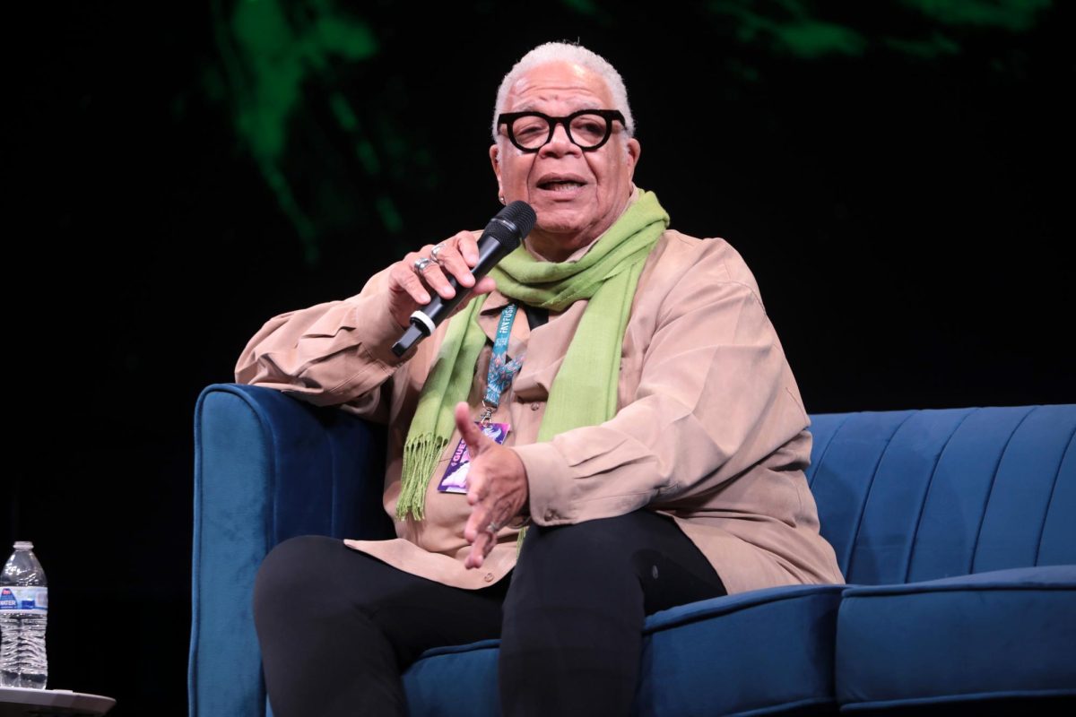 Ken Page, star voice and screen actor, speaking on stage to people around them. They explained using expression and hand motions towards the crowd while explaining. (Photo by Gage Skidmore.)