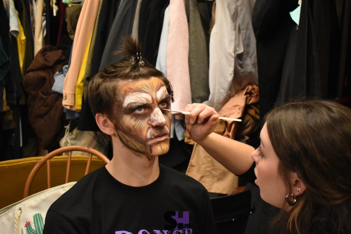 On opening night, Nov. 14, Quorynn Harris, 12, puts makeup on Andon Mattox, 12, who played The Beast.