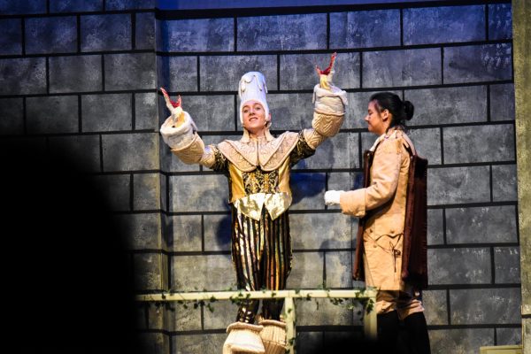 Lumière, played by Henry Seitz, 12, and Cogsworth, played by Liang, discuss the news of Belle arriving to the Beast's castle (Photo by D. Estes)