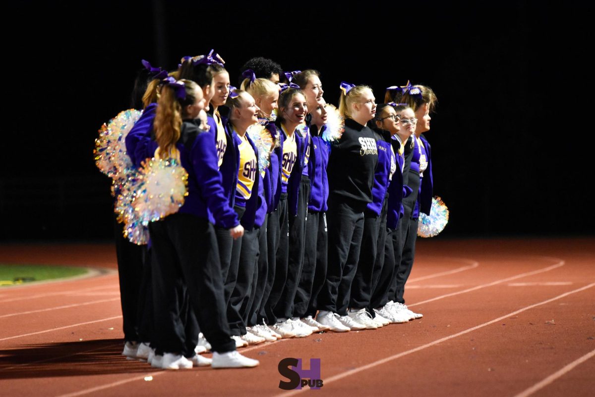 On Nov. 1, members of the cheer team link arms and sway together while the band plays the alma mater.