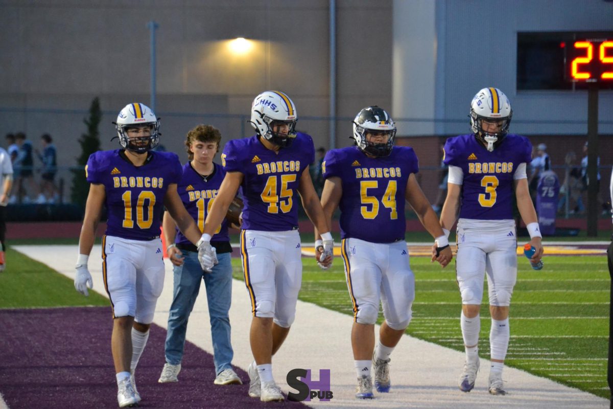 Hank Kotchavar, 11, Beau Gardner, 12, Logan Alexander, and Treyson Schuckman, 10, hold hands as they walk onto the field before the game Oct. 11.