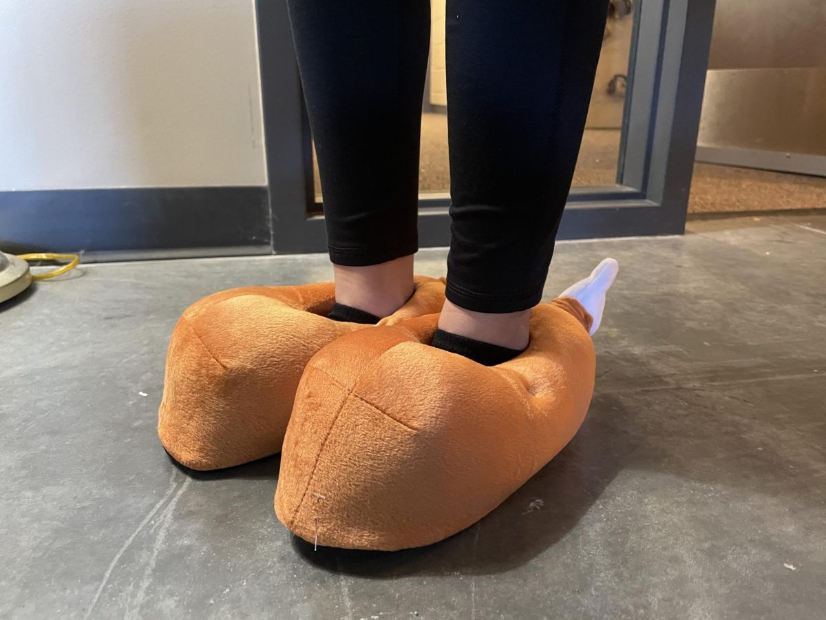 Kayley Tran, 11, shows off their Thanksgiving spirit with some wacky turkey slippers. (Photo by Macey Chaulk)