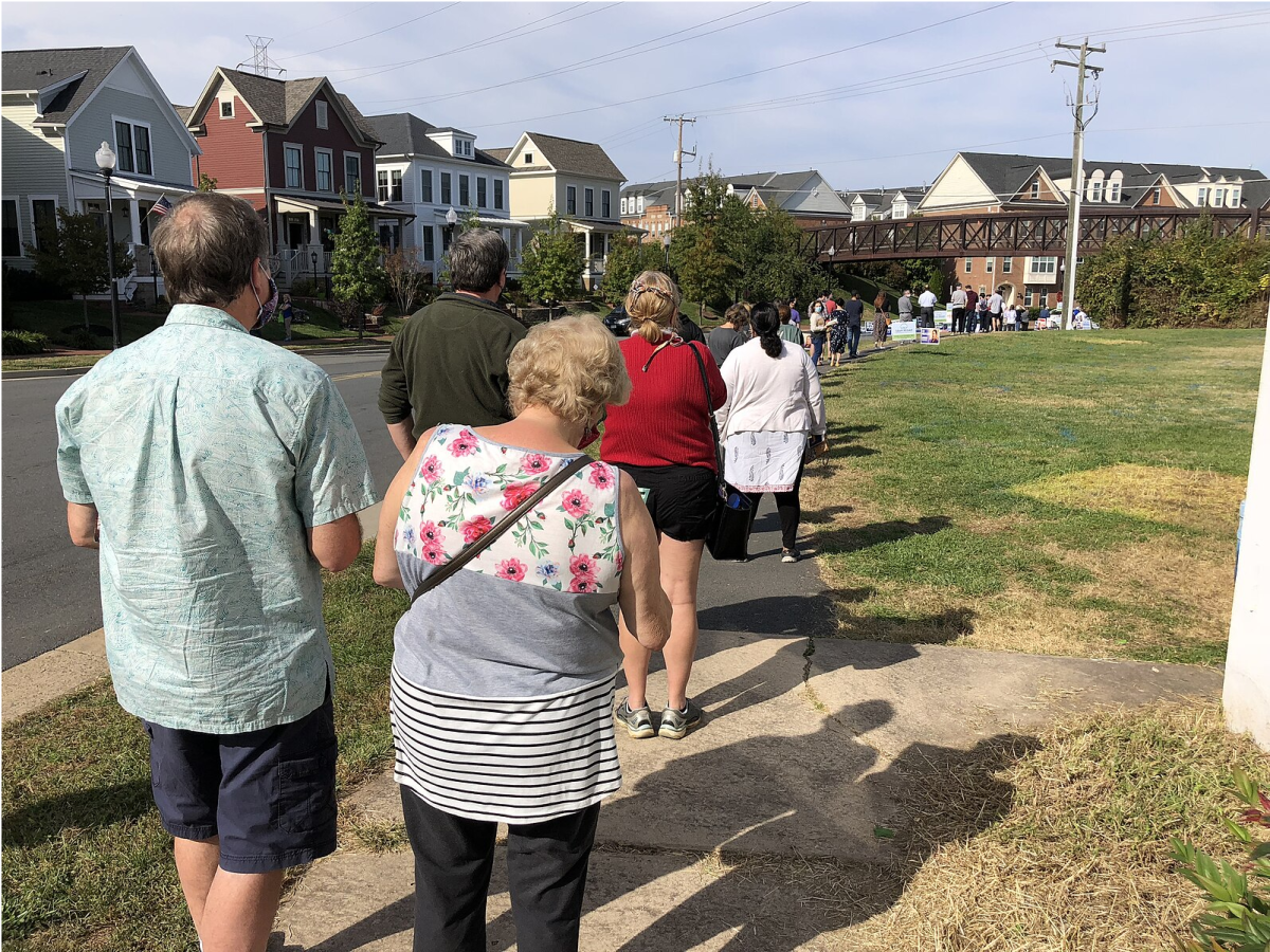 People line up down the block to vote. These lines can be very long on election day, so some choose to vote early (Photo by Famartin).