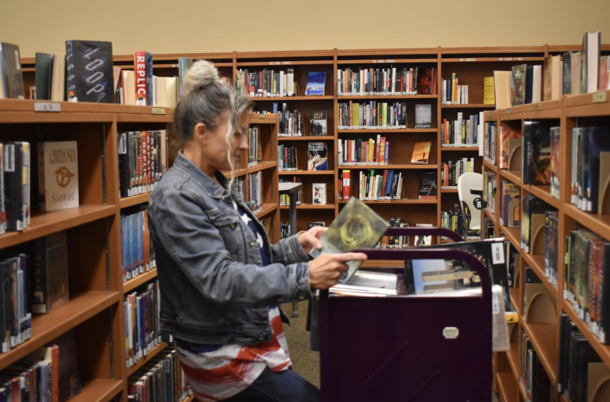 Cochran works in the library on an average day. They have been working at the library for four years. (Photo by P. Creach)