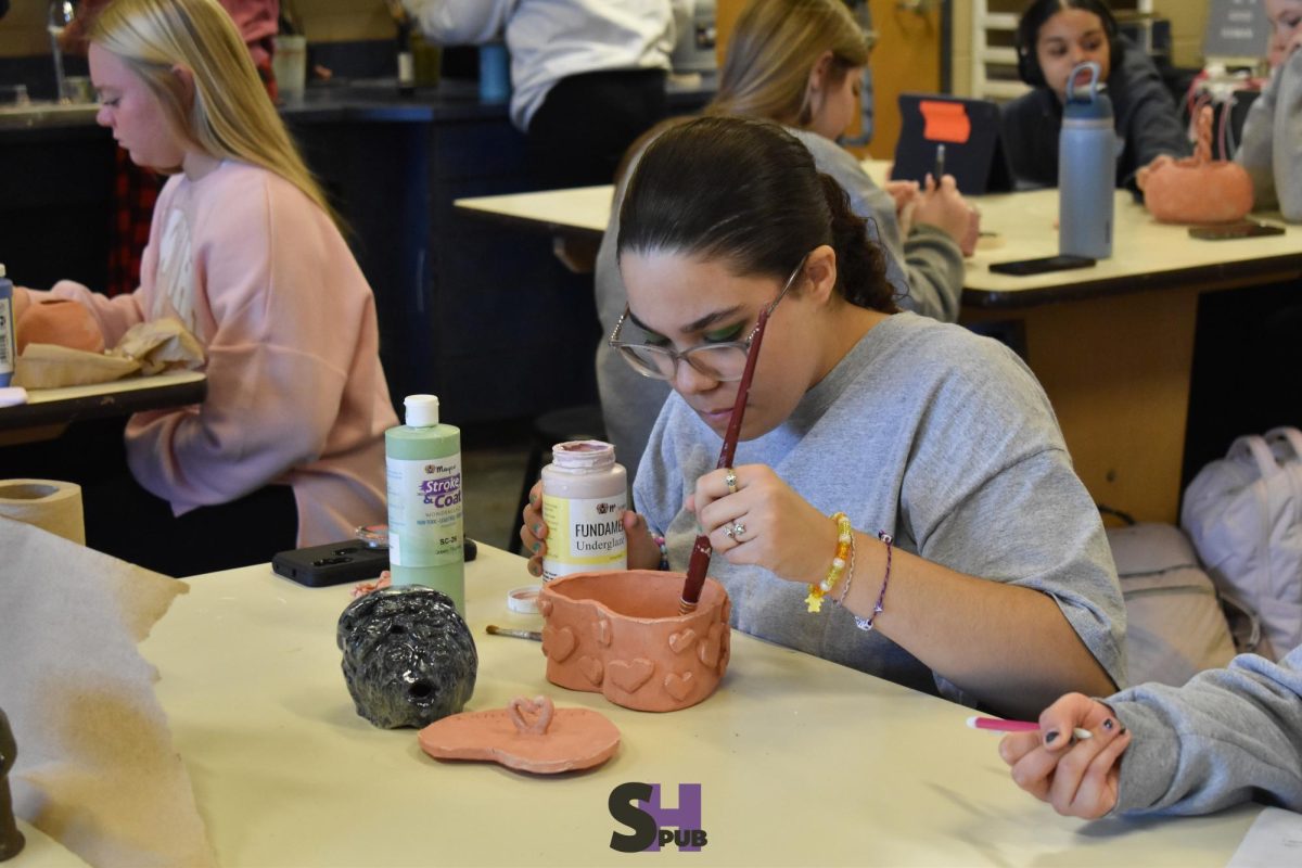 Alexis Fuel-Tyner, 10, glazes the inside of their heart-shaped pot Dec. 2.