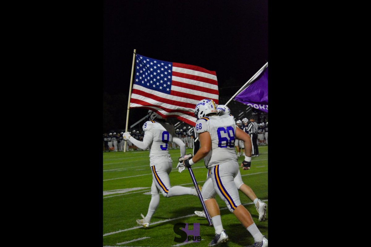 Jackson Torrez and Gage Wingerter, 12, run onto the field before a football game Nov. 8.