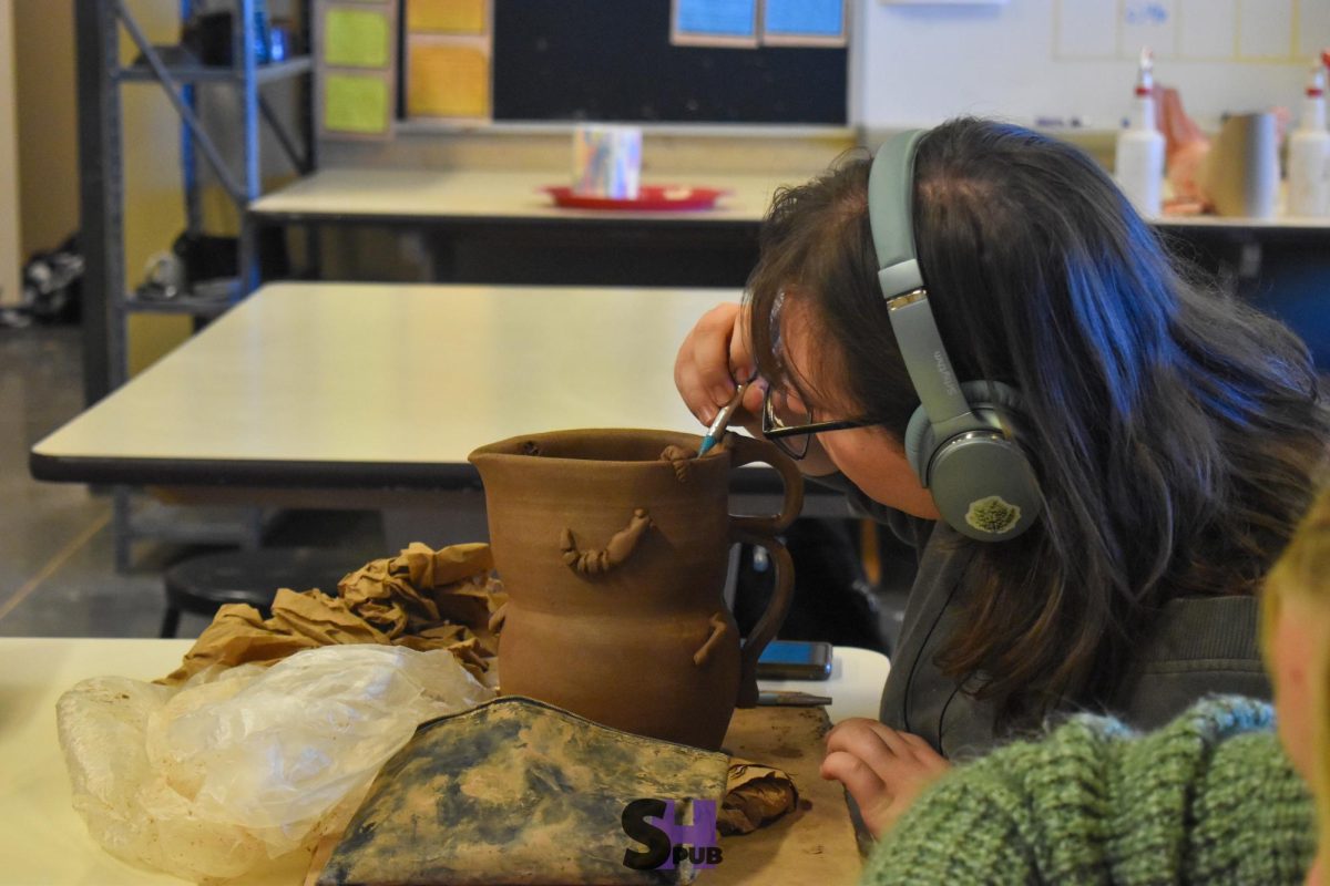 During ceramics, 4, Ava Rushing, 12, adds bugs for embellishment on the outside of a water pitcher Nov. 13.