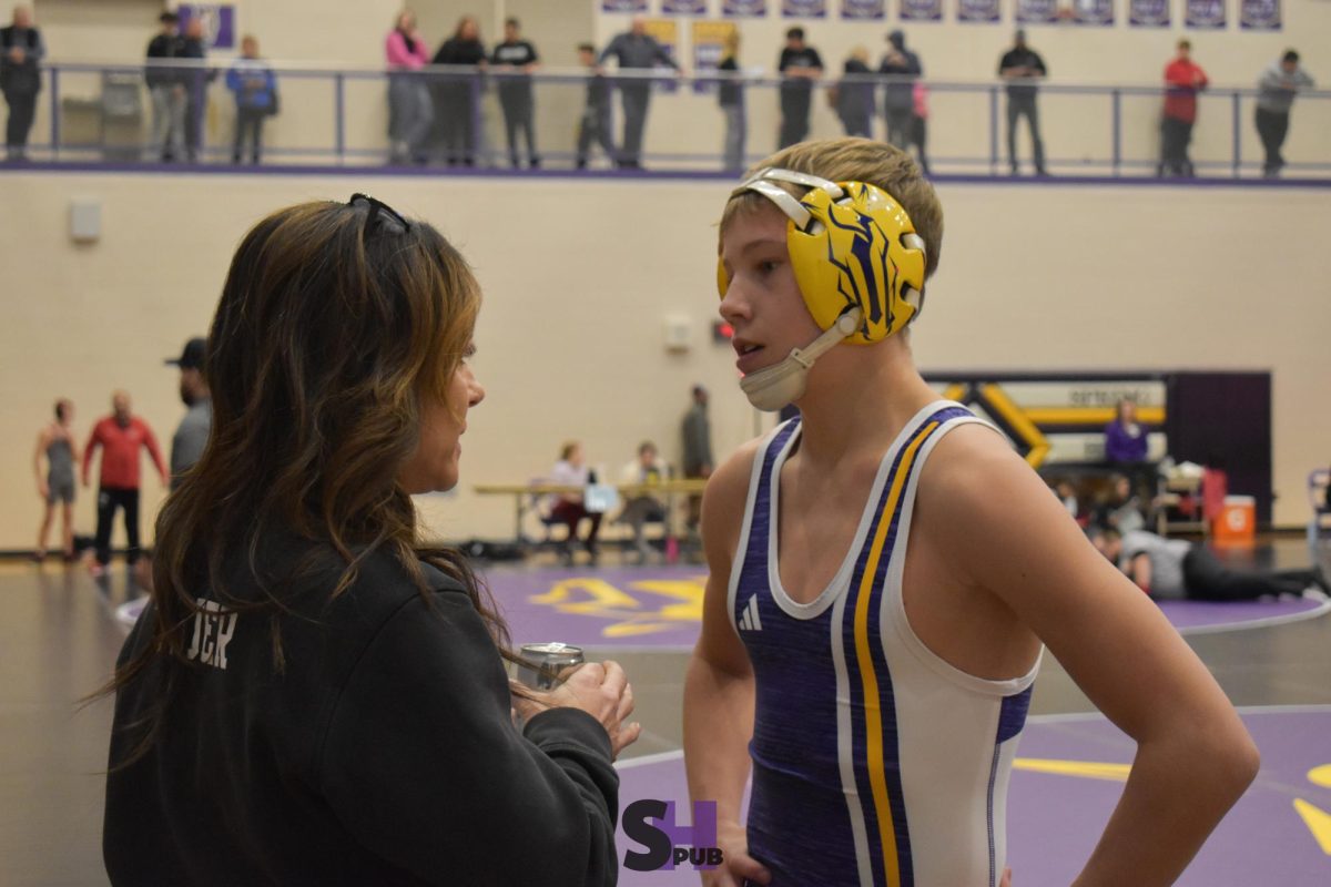 Brody Bremerman, 9, discusses a recent match with wrestling coach Angie Tauer Dec. 5.